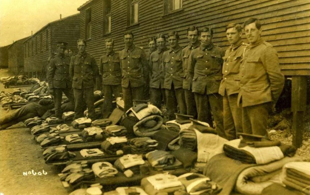 Soldiers standing for kit inspection outside their hut.